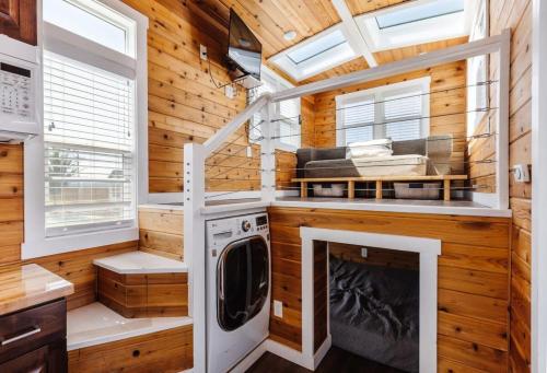 a tiny house with a fireplace and a washer and dryer at Harrington Tiny House in Apple Valley