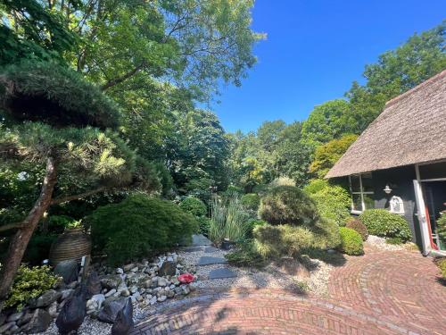 a garden with rocks and trees and a house at Dream apartments in Hoogwoud