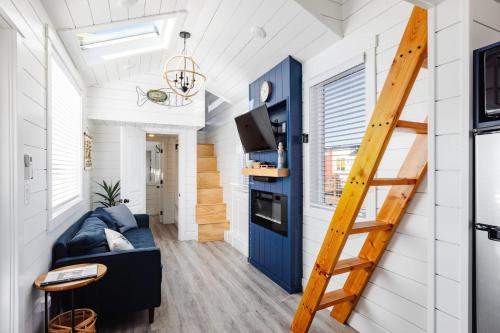 a tiny house with a blue door and a staircase at Starboard Tiny Home in Apple Valley