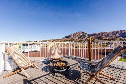 a deck with two chairs and a fire pit at Zion Stay, Scenic Tiny Home & Sunset Views in Apple Valley