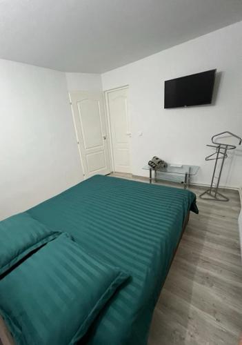 a bedroom with a green bed and a flat screen tv at Casa Dragoeni, Targu Jiu in Târgu Jiu