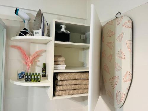 a bathroom with shelves with towels and a surfboard at Studio 4 couchages à 200 m de la plage + garage in Juan-les-Pins