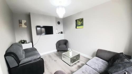 uma sala de estar com um sofá e uma cadeira em 293 Holiday Home em Belfast