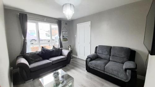 sala de estar con sofá y silla en 293 Holiday Home, en Belfast
