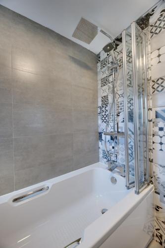 a bathroom with a white tub and a shower at Lionsgate View - luxury apartment opposite Alnwick Castle in Alnwick