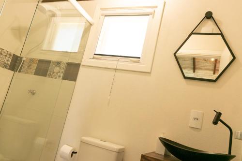 La salle de bains est pourvue d'un lavabo, de toilettes et d'une fenêtre. dans l'établissement Chalé Esmeralda na Amarte perto do Templo Budista, à Três Coroas