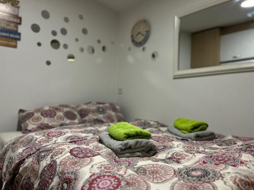 1 dormitorio con 1 cama con toallas verdes en Nilton 2 Apartmans en Niš