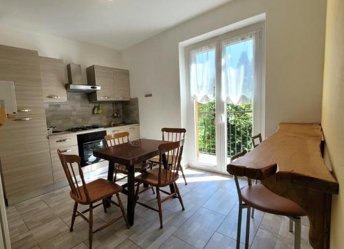 a kitchen with a table and chairs and a dining room at Green House Mountain Lake Iseo Hospitality in Bossico