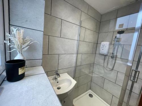 een badkamer met een douche, een toilet en een wastafel bij Manvers house city centre in Nottingham