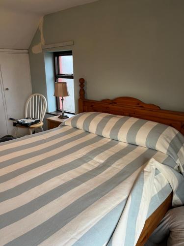 um quarto com uma cama, uma cadeira e uma janela em Reenard South seaview country cottage em Cahersiveen