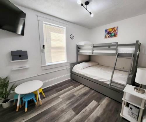 - une chambre avec des lits superposés et une table dans l'établissement Beach Oasis, Mins to CP & SF, King/WD/Pet OK, à Sandusky