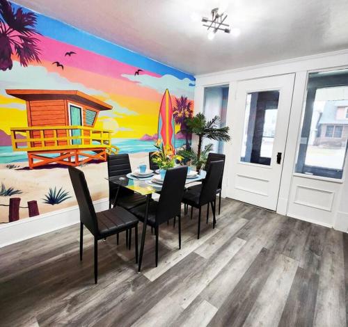 uma sala de jantar com uma mesa e cadeiras com um mural de praia em Beach Oasis, Mins to CP & SF, King/WD/Pet OK em Sandusky