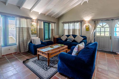 a living room with blue couches and a coffee table at Beach House In Crown Point- walk to the beach in Bon Accord