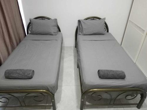 - deux lits assis l'un à côté de l'autre dans une pièce dans l'établissement Pacific Apartment, à Suva