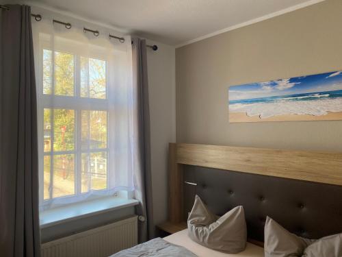 a bedroom with a bed and a window with a bath tub at Pension Zum Alten Fährhaus in Rostock