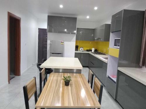 una cocina con mesa de madera y sillas. en Pacific Apartment, en Suva