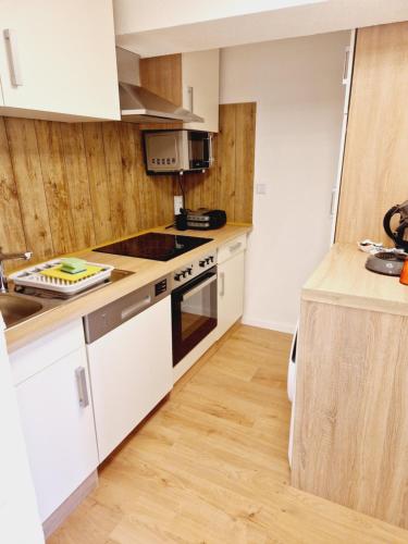 a kitchen with white appliances and a wooden floor at Ferienwohnung Wehra in Wehr