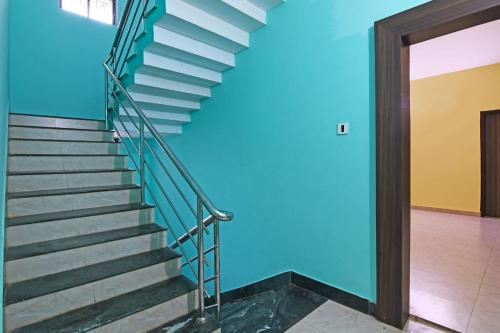 a staircase in a building with a blue wall at OYO Flagship Samrudhi Residency in Jānla