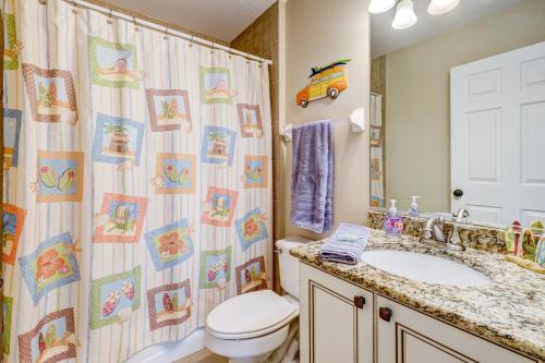a bathroom with a shower curtain with a toilet and a sink at Sea Site Retreat Unit B! Great attractions nearby! Short walk to the beach! in Bradenton Beach