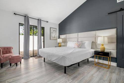 una camera da letto con un letto grande e una sedia di Tropical Tranquility! Luxury pool home with lakefront view just minutes from the beach! a Bradenton