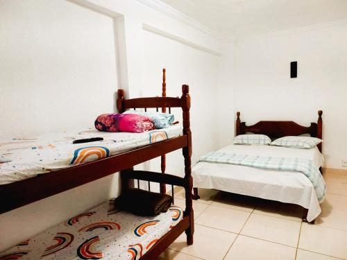 1 Schlafzimmer mit 2 Etagenbetten in einem Zimmer in der Unterkunft Suíte Privativa com Ar Condicionado TV Frigobar 102 in Cabo Frio