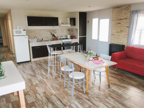 Una sala de estar con una mesa y un sofá rojo. en ESTEPA CHIMEN, en Río Gallegos