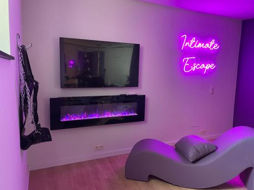 sala de estar con chimenea y cartel de neón en Love room - Intimate Escape, en Arlon