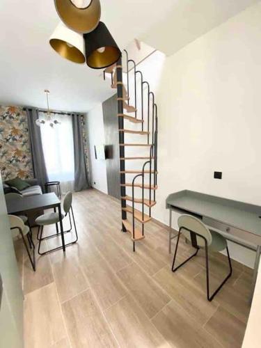 - un salon avec un escalier, une table et des chaises dans l'établissement Appartement Chic au calme, à Gentilly