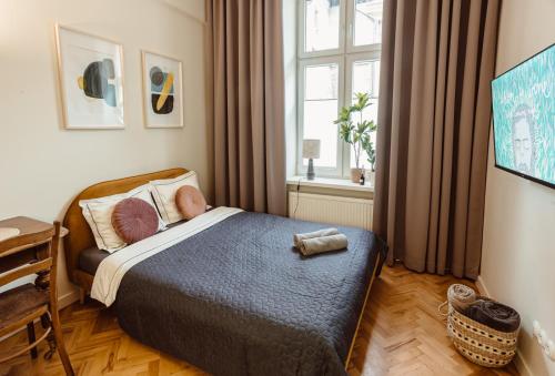 a small bedroom with a bed and a window at Apartament na Krakowskim Kazimierzu in Krakow