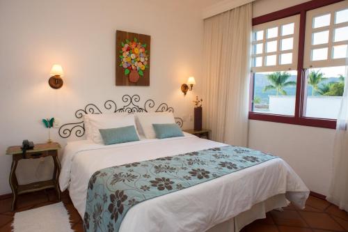 een slaapkamer met een groot bed en een raam bij Pousada Bárbara Bela in Tiradentes