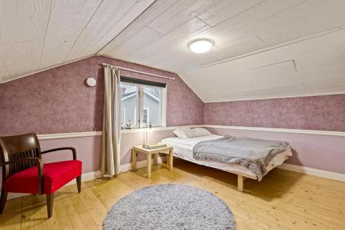 a bedroom with a bed and a chair and a window at Comfy 4-bedroom barnhouse Ideal for Long Stays in Åkersberga
