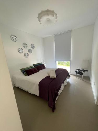 um quarto com uma cama grande e relógios na parede em Rinconada del Mar em Punta del Este