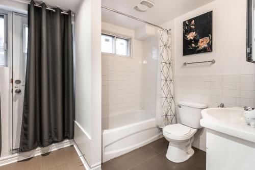 Baño blanco con aseo y lavamanos en Grand appartement 4 chambres - 335, en Montreal