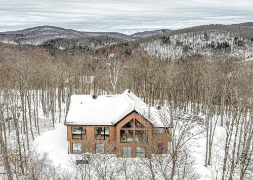 a house with snow on the roof in the woods at The Chic Shack - Golf, Ski, SPA in Saint-Faustin