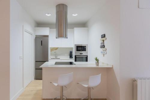 een keuken met witte werkbladen en witte apparaten bij La cruz cozy apartment by Next Stop Bilbao in Bilbao