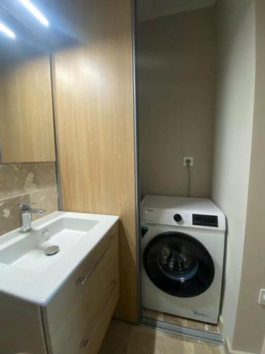 une salle de bain avec une machine à laver et un lavabo dans l'établissement Duplex sur Nice - Libération, à Nice