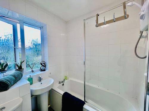 y baño con lavabo, bañera y ducha. en Brand New! The Cosy Cove by Artisan Stays I Free Parking I Weekly or Monthly Stay Offer I Sleeps 5, en Chelmsford