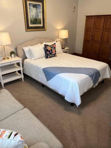 a bedroom with a bed and two tables and a couch at Spacious Suite Wkitchenette in Ligonier