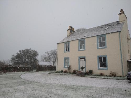 a white house with a driveway in front of it at Kirkland House B&B in Tarbert