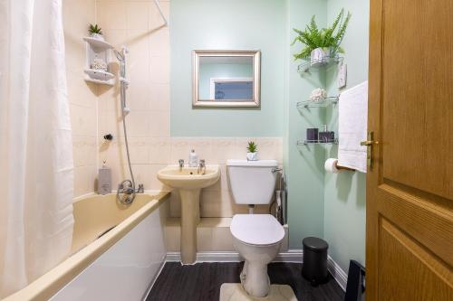 a small bathroom with a toilet and a sink at Cozy Family-Friendly House (3mins from Erith and Slade Green station) in Erith