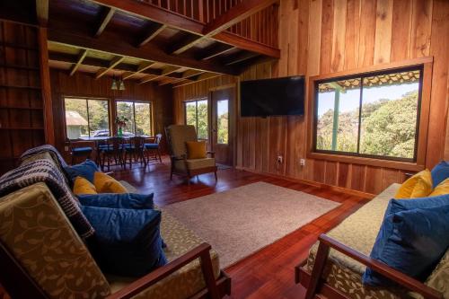 a living room with a couch and a television at Mountain Wonders Chalet in Monteverde Costa Rica
