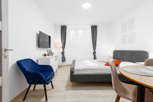 ein Schlafzimmer mit einem Bett und einem Tisch mit einem blauen Stuhl in der Unterkunft 2 bedrooms apartment near the metro in Prag