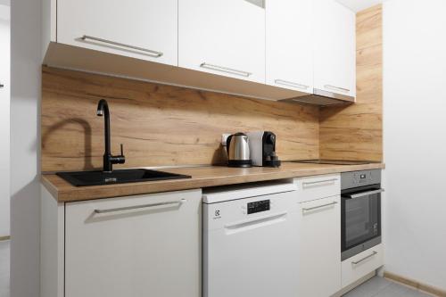 eine Küche mit weißen Schränken und einer Spüle in der Unterkunft 2 bedrooms apartment near the metro in Prag