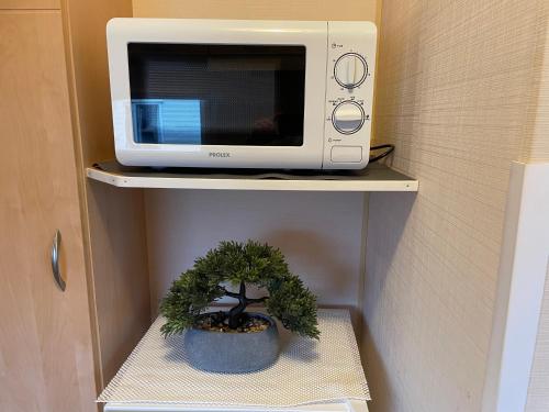 a plant in a pot next to a microwave at BelLa VistA - Holiday Home On The Beach in Clacton-on-Sea