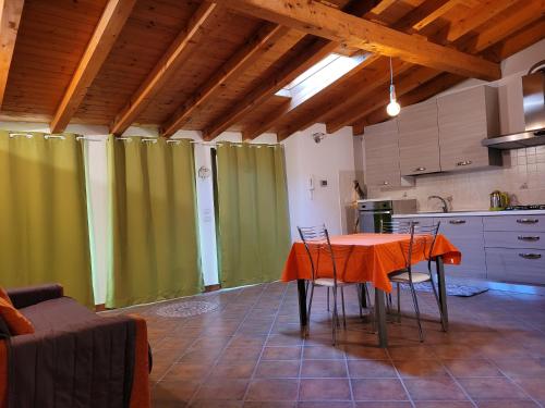 ボッシコにあるIl nido in montagna Mountain Lake Iseo Hospitalityのキッチン(緑のカーテン、テーブル、椅子付)