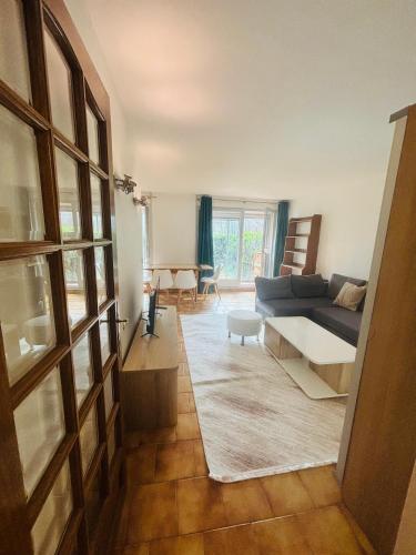 un salon avec un canapé et une table dans l'établissement F2 avec Terrasse, Parking gratuit, à Guyancourt