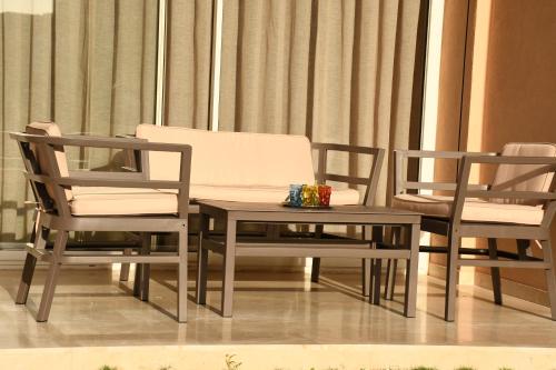 two chairs and a table with a couch in a room at Luxueux & Haut Standing OceanSwing Stay Taghazout Bay in Agadir