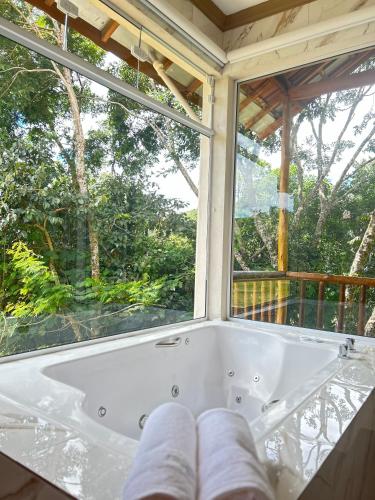 a bath tub sitting in front of a window at Chales Maria Flor in Gonçalves