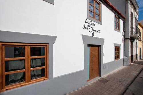 a white building with a door on a street at La Casa de San Juan - BENTEJUI in Telde