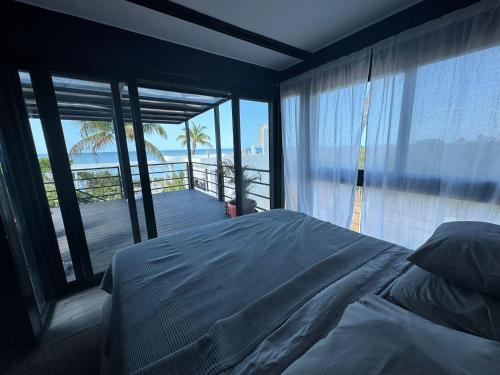 a bedroom with a bed and a view of the ocean at Casa Arsha Beachfront Paradise in Santa Clara